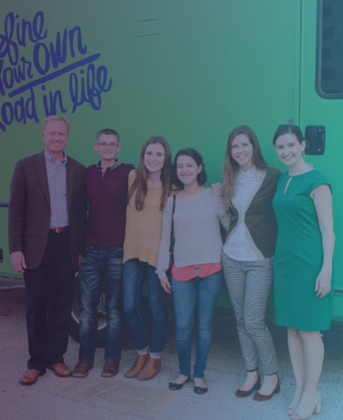 Tres adolescentes y tres miembros del equipo Texas OnCourse frente al autobús verde brillante Roadtrip Nation