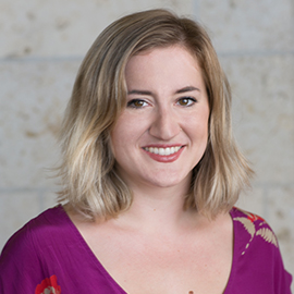 Headshot of Katie Stone - smiling woman in purple floral blouse