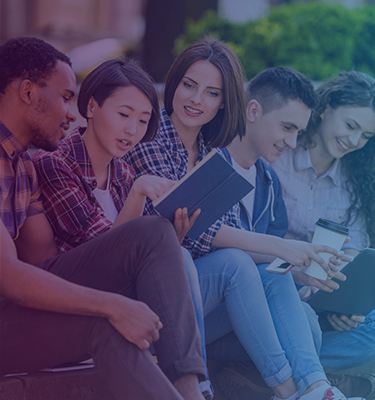 College-aged students gathered around a book