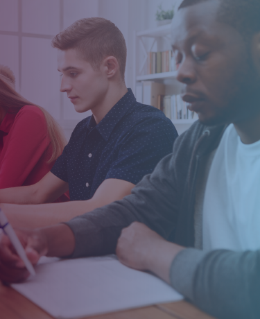 Three young adults focused on paperwork in office setting