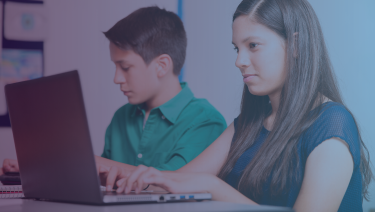 Dos niños latinos en las computadoras portátiles