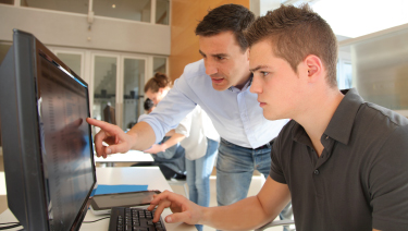 Man pointing at computer with teen